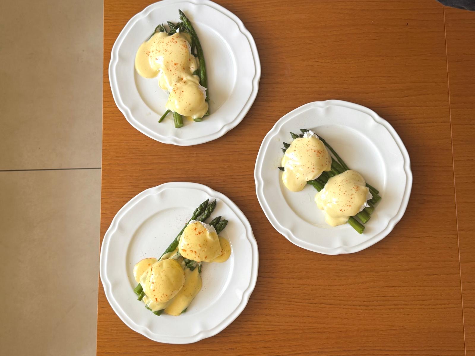Asparagus with hollandaise served on white plates
