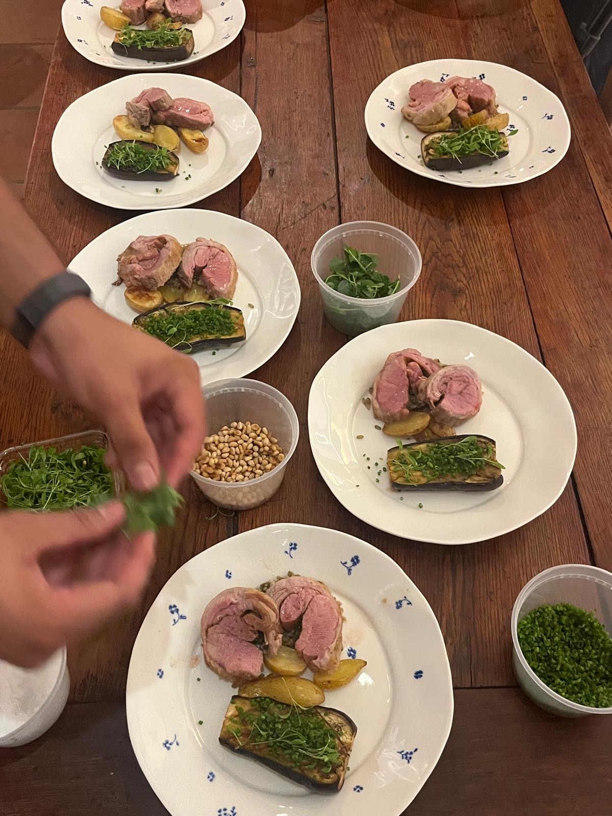 Lamb, aubergine and potatoes being plated for dinner service
