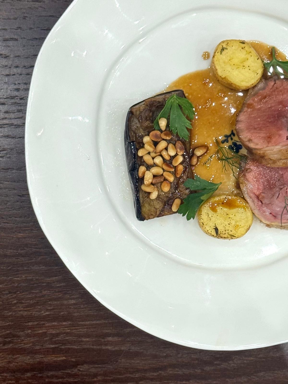 Seared beef with aubergine, potatoes and herbs, plated for a private dinner